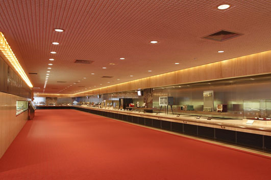 Exhibition hall of the Sharp Technology Innovation Museum, lined with display cases along a red-carpeted corridor